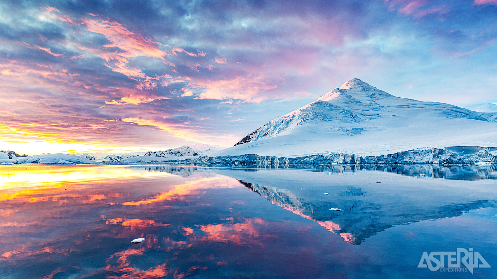 Wanneer de zon zakt onder de horizon van Antarctica, ontvouwt zich een magisch kleurenpalet van goud, roze en paars