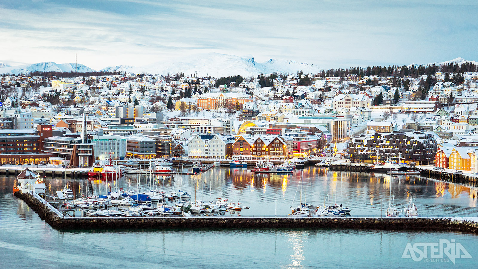 De haven van Tromsø met besneeuwde kades en zicht op de stad