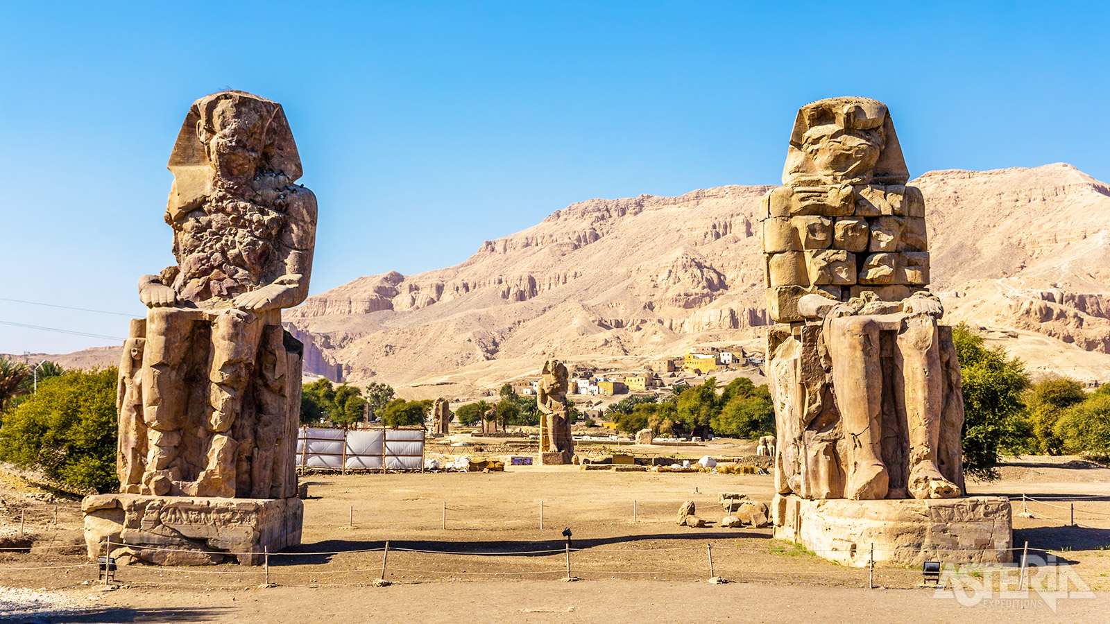 De Kolossen van Memnon zijn 2 gigantische standbeelden van steen, zo’n 18m hoog