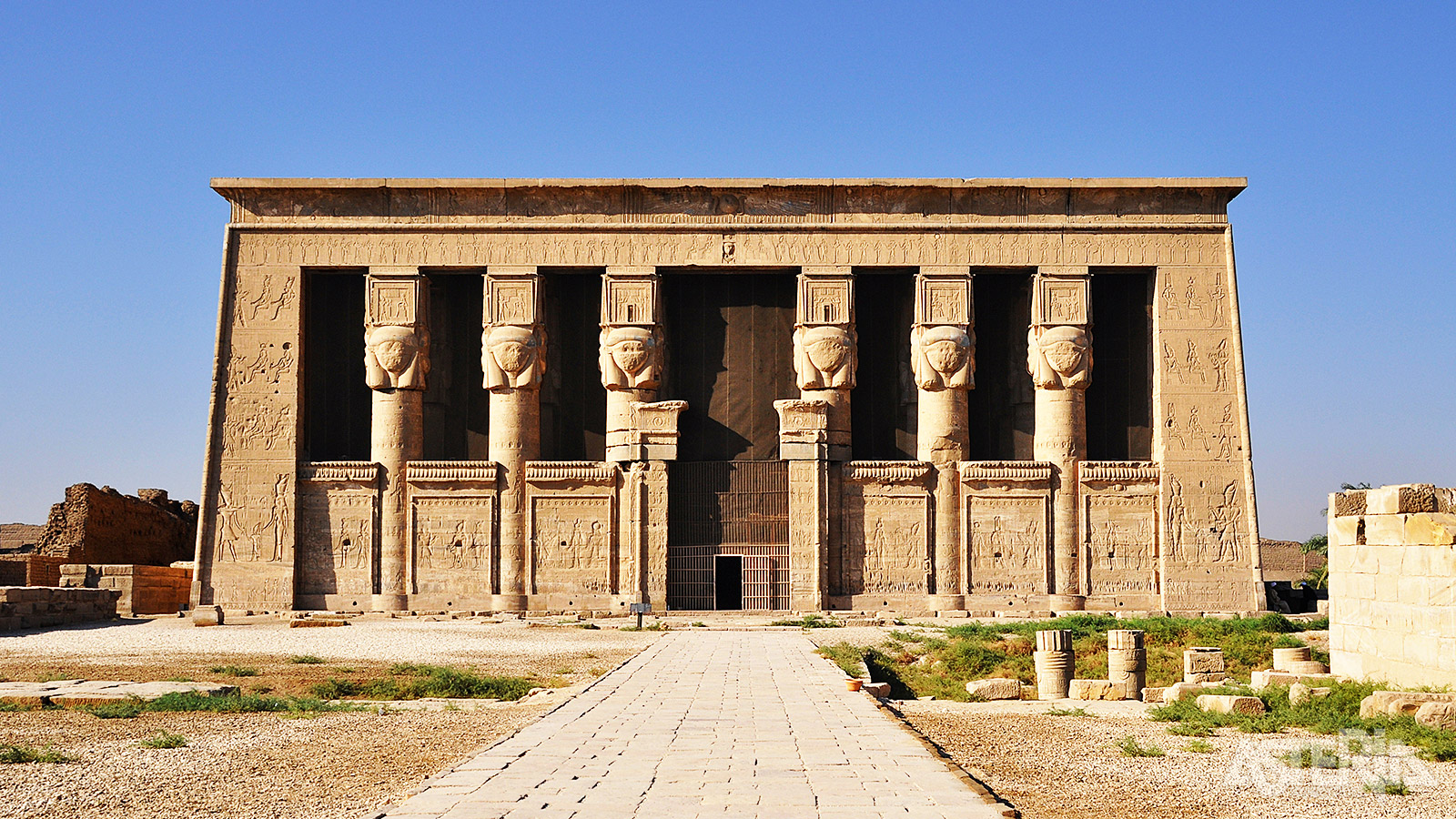 Bijzonder indrukwekkend aan Denderah is de monumentale gevel met de karakteristieke zuilen met het hoofd van Hathor
