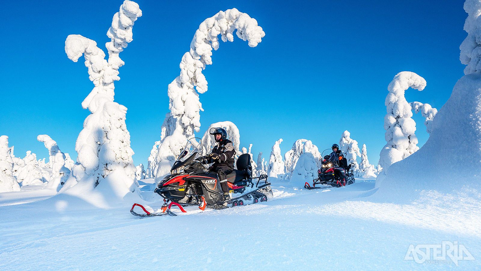 Vertrek met de sneeuwscooter voor een spannende tocht door besneeuwde bossen, langs heuvels en over bevroren meren