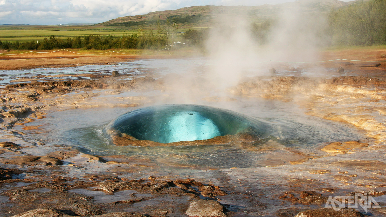 De actieve Strokkur-geiser spuit om de 8  10 minutes een kokende waterzuil 30m hoog de lucht in