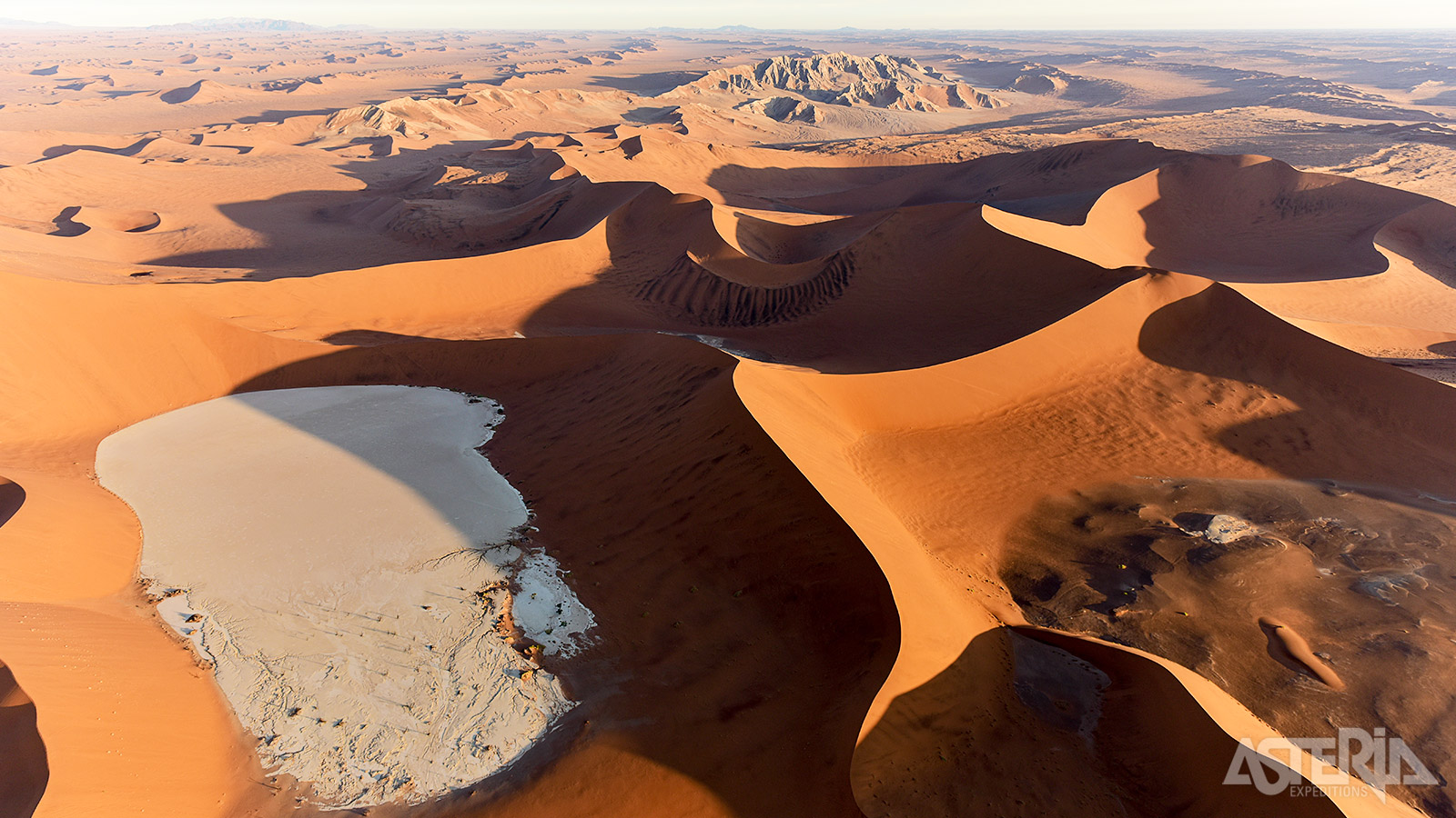 Wind en mist creeërden zoutpannen en dieprode zandduinen, waarvan sommige meer dan 350m boven de woestijn uitsteken