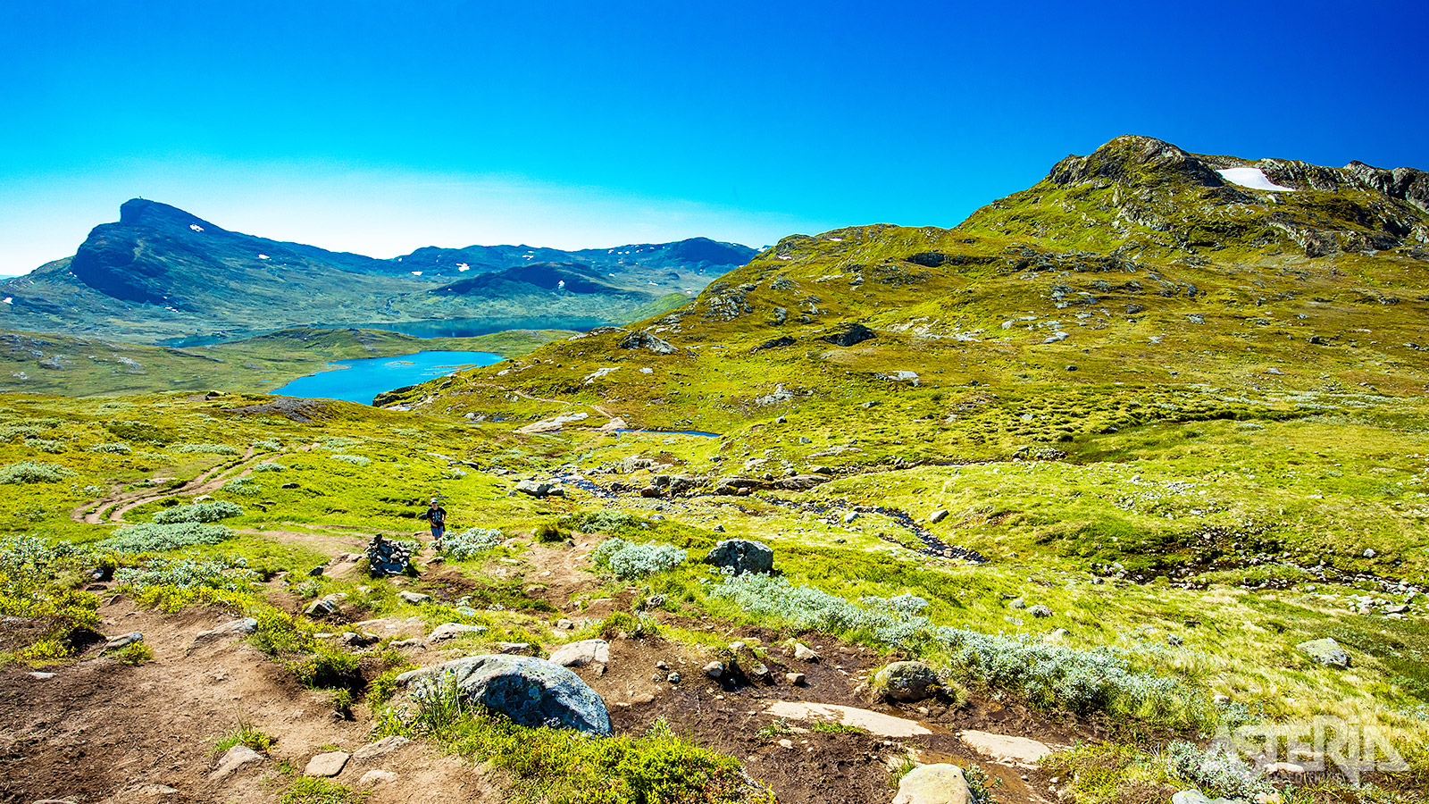Je rijdt door een spectaculair alpien landschap met steile wanden en diepe dalen die gevormd zijn door eeuwenlange gletsjerwerking