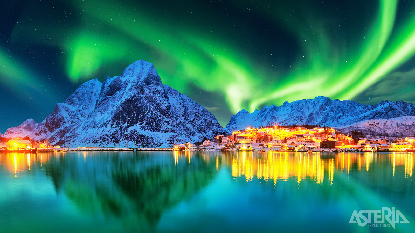 In de winter zorgen besneeuwde bergtoppen en het noorderlicht over de Lofoten voor een magisch landschap