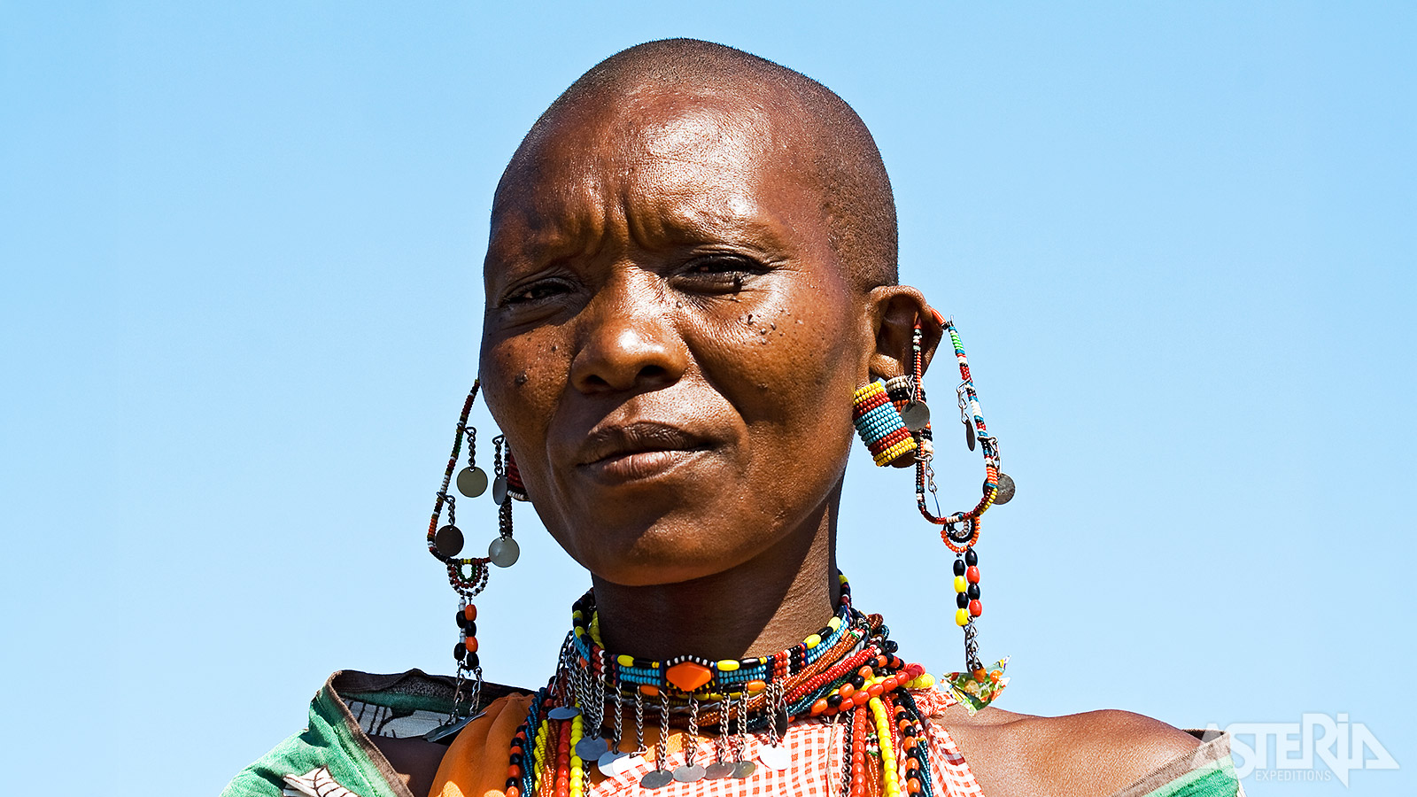 Een Masai vrouw met kleurrijke, handgemaakte juwelen die haar cultuur weerspiegelen