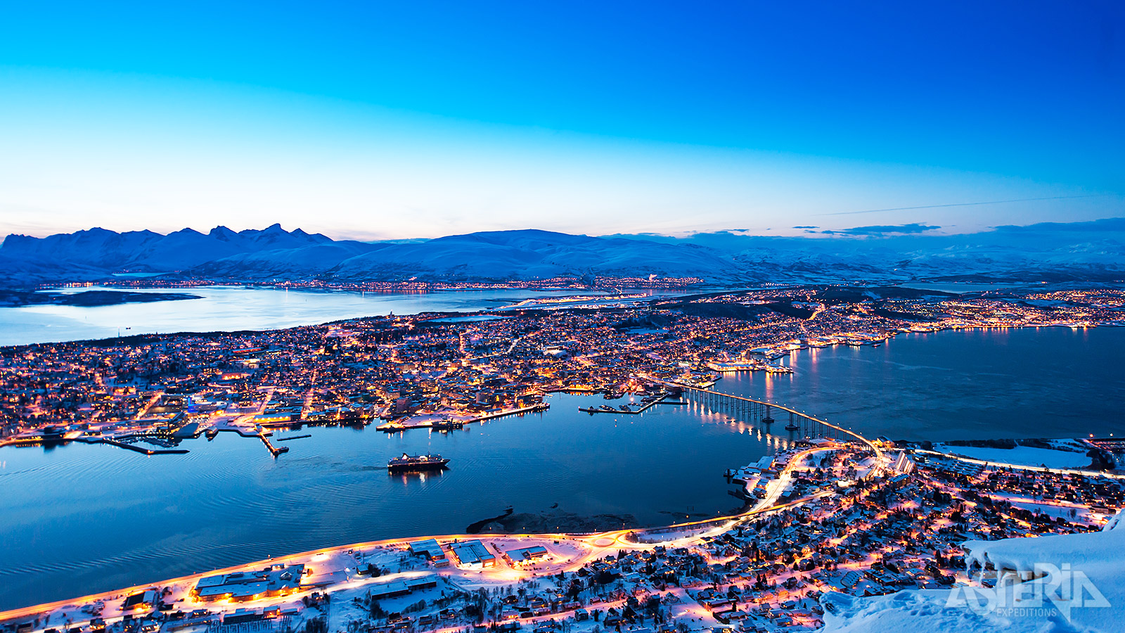 In Noord-Noorwegen ligt Tromsø, omgeven door fjorden, bergtoppen en baaien